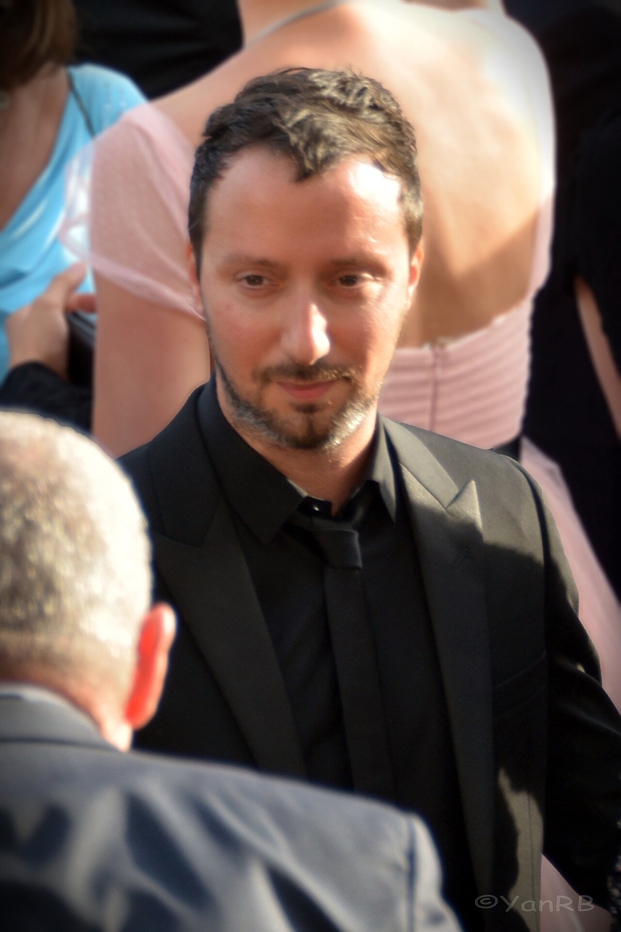 Anthony Vaccarello en 2017, portrait en buste, veste sombre, fond clair.